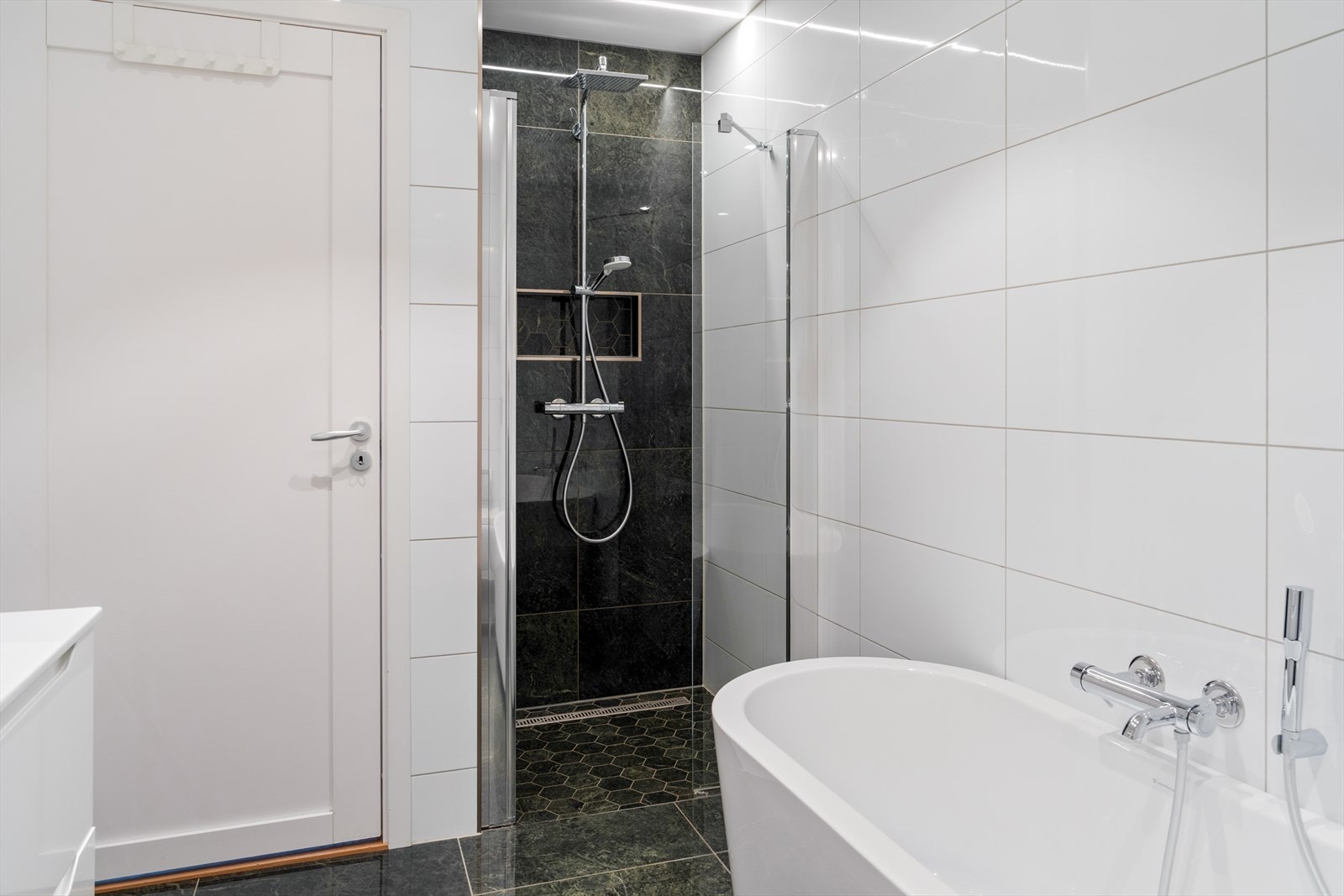 Badet måler 7,4 m² og er helfliset Galleribilde