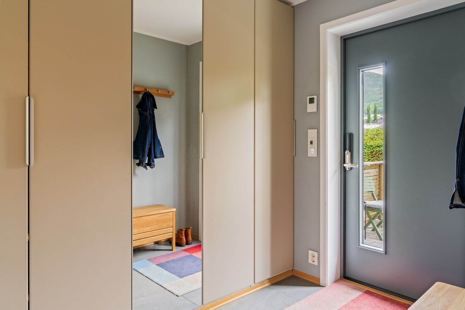 Velkommen inn! | Du blir møtt av en lys og romslig entré med varme i gulv innredet med stor garderobe med speil Galleribilde