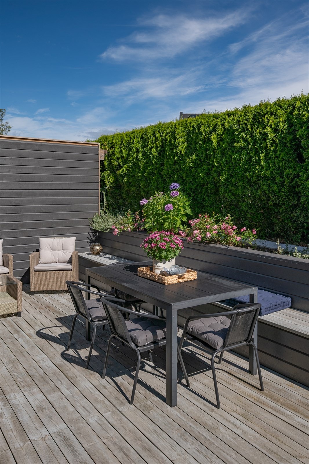 Fastmontert benk og store plantekasser rammer inn uteplassen. Galleribilde