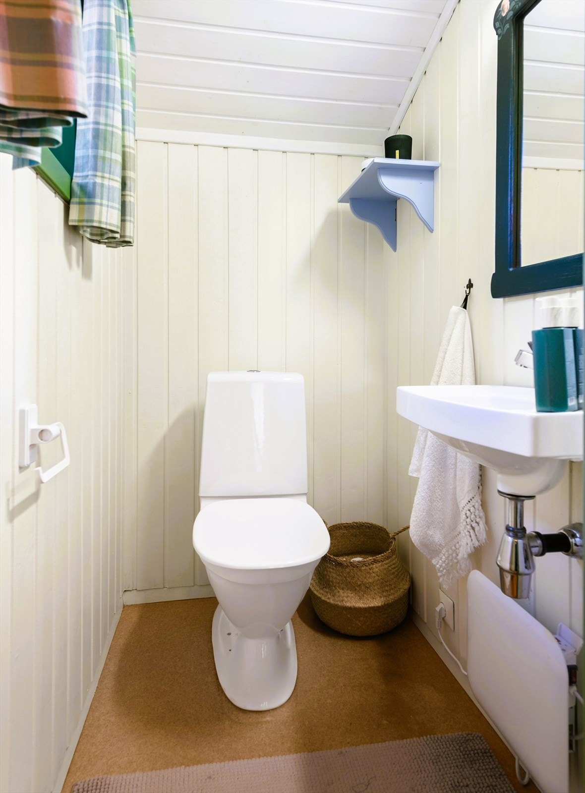 Separat wc-rom med gulvstående toalett og enkel servantinnredning på vegg. Galleribilde