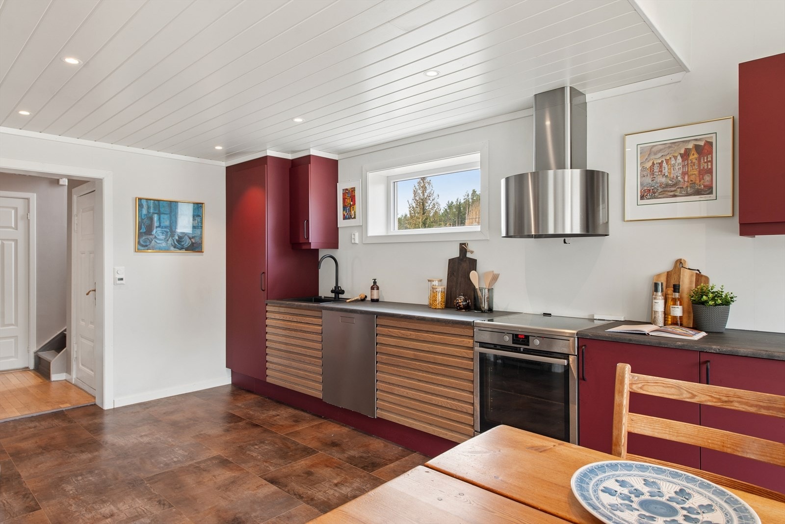 Det er god plass til et spisebord foran vinduene, og en dør gir direkte utgang til overbygget terrasse - ideell for måltider utendørs og hyggelige stunder i frisk luft. Galleribilde