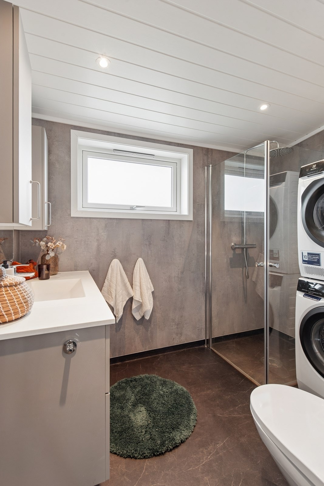 Badet ble bygget om i 2024 og har elektriske varmekabler i gulvet, baderomsplater på veggene og opplegg for vaskemaskin. Galleribilde