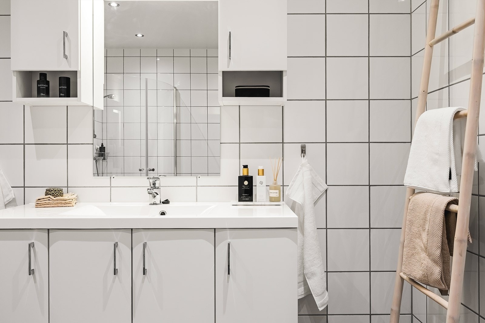 Baderomsinnredning med heldekkende servant og speilskap med belysning. Galleribilde