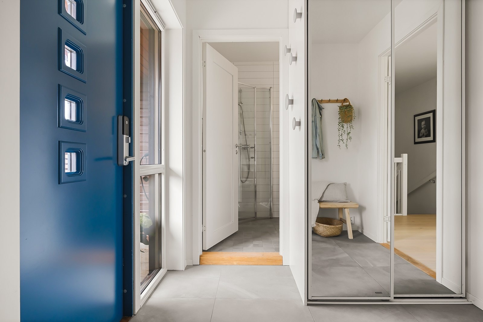 Entré med keramiske fliser på gulv og en praktisk skyvedørsgarderobe. Galleribilde