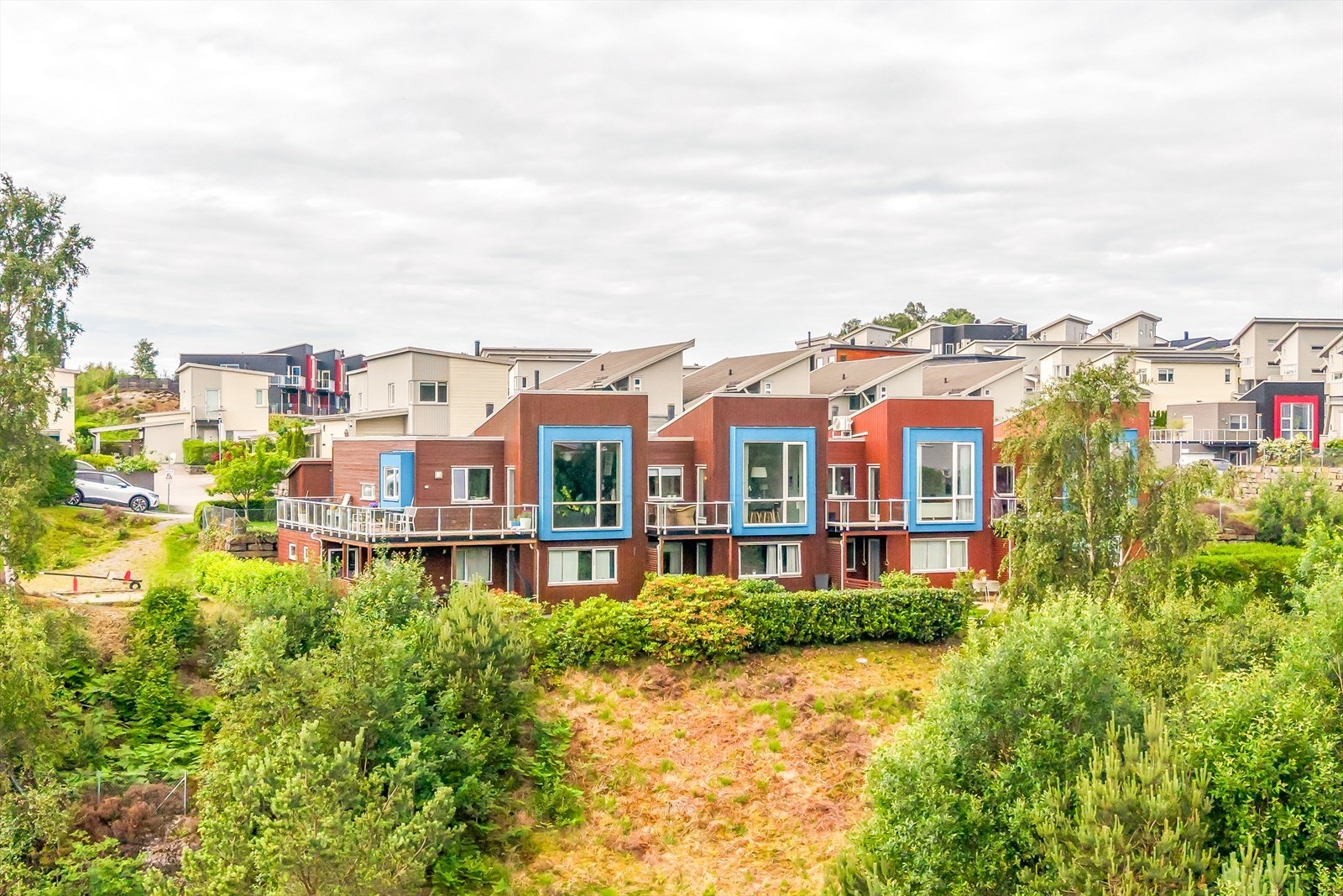 Rekkehuset har en moderne arkitektur med beiset trekledning og karakteristiske detaljer. Galleribilde