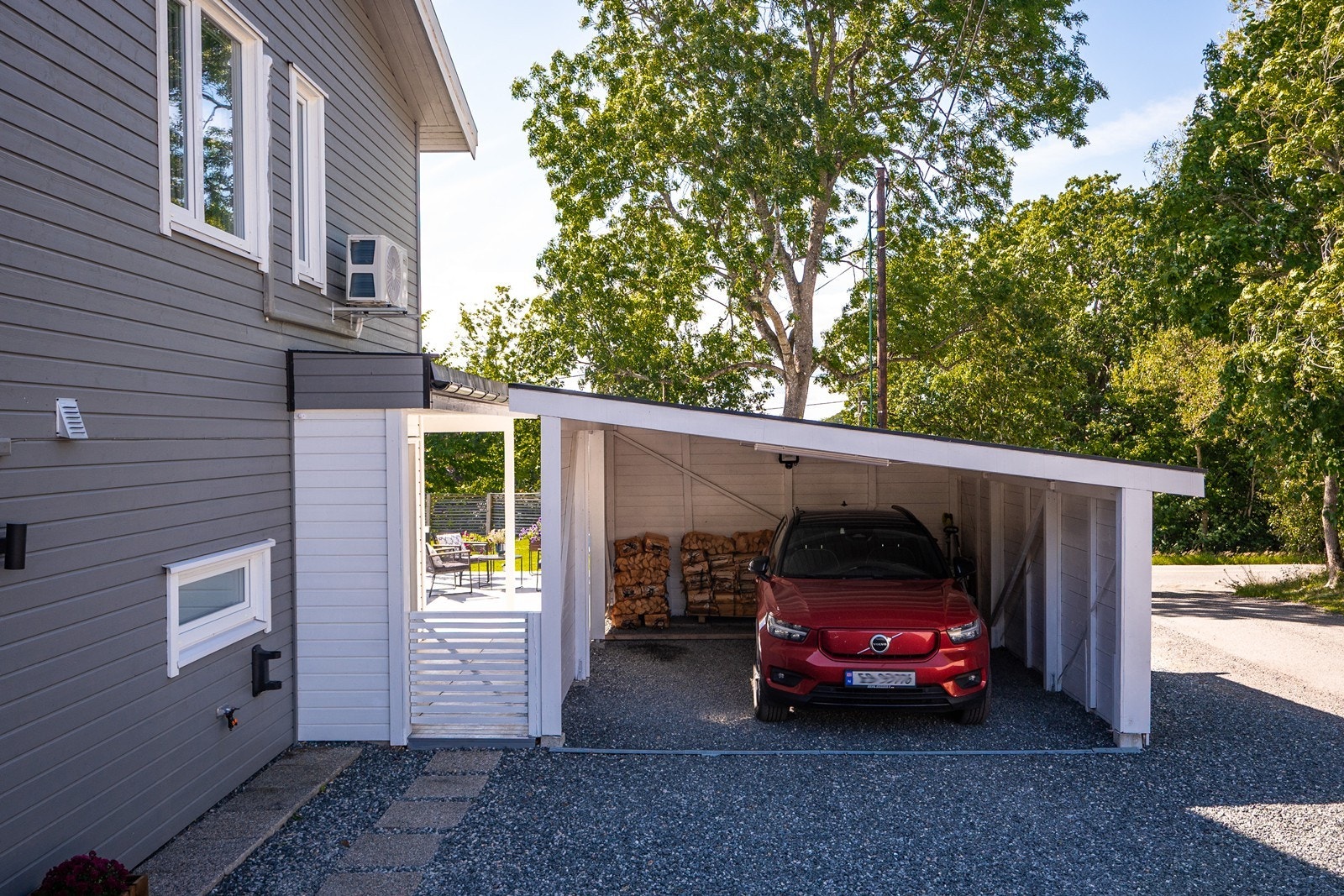 På nordsiden er det enkel parkering i carport. Steinheller som følger hushjørnet er nylig lagt. Galleribilde