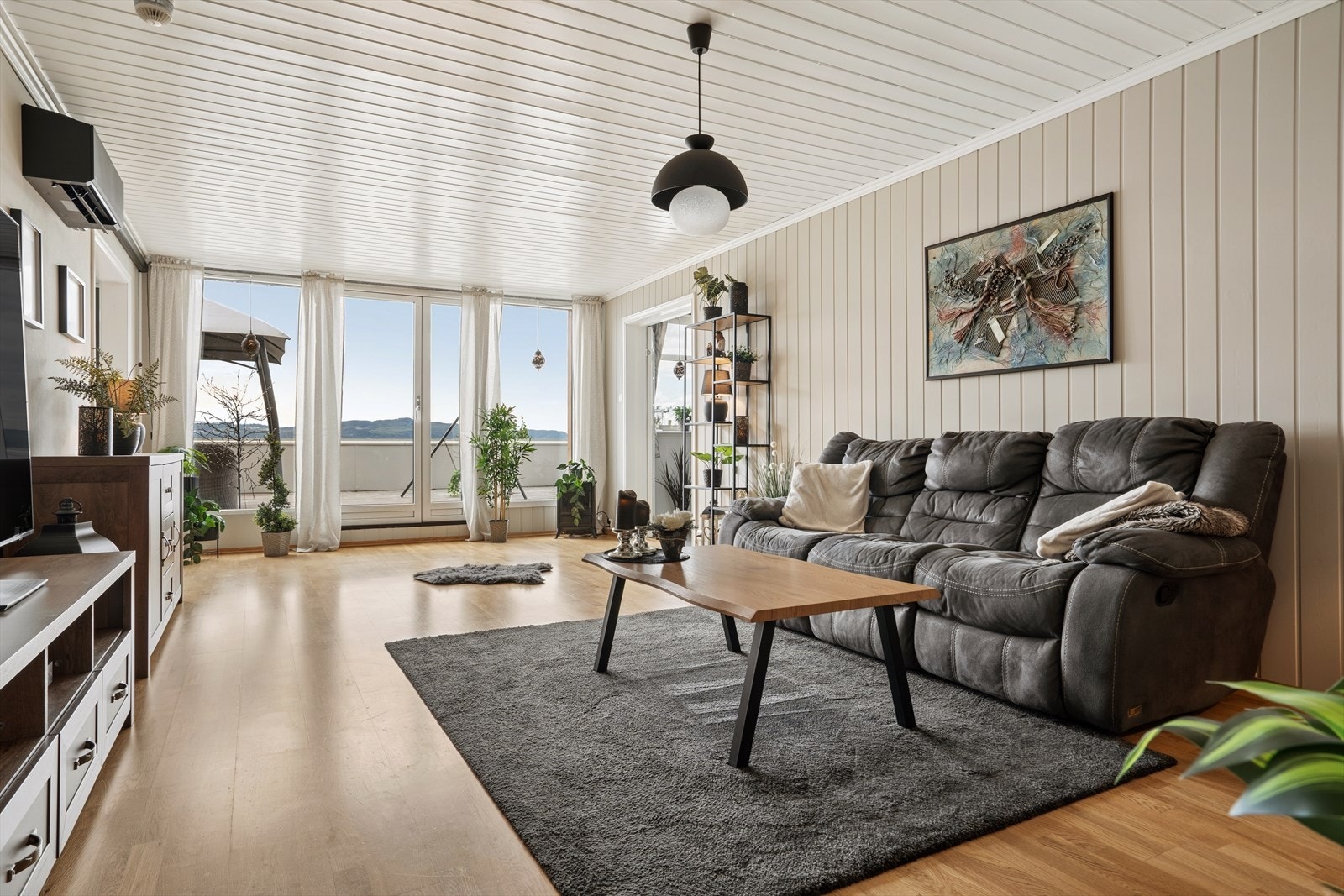 Lys og romslig stue med store vindusflater og utgang til solrik terrasse med flott utsikt. Galleribilde