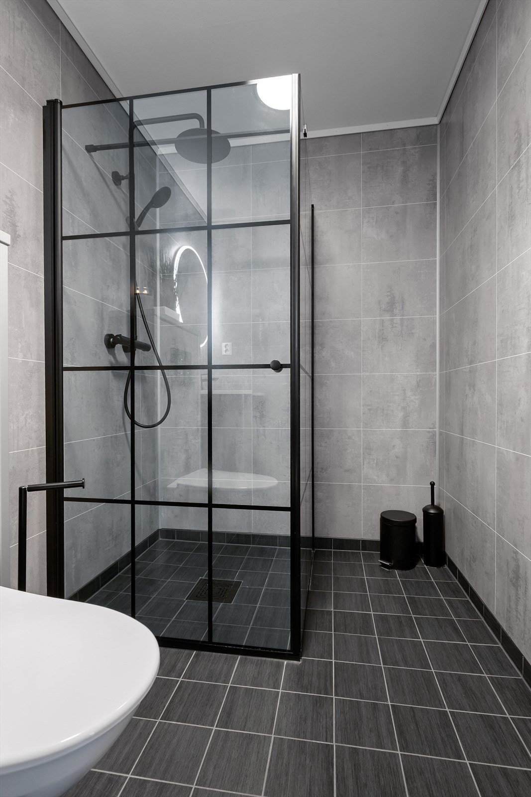 Badet har flislagt gulv med varmekabel og baderomsplater på vegger. Galleribilde