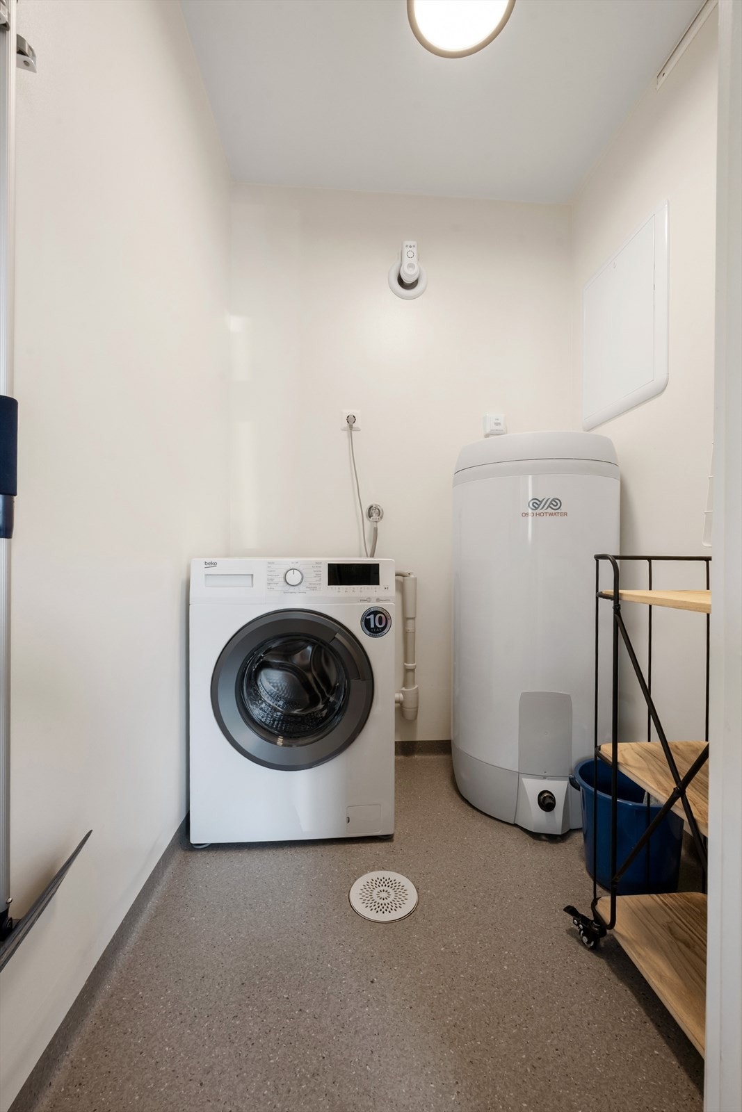 Vaskerommet har vinylbelegg på gulv. Rommet er innredet med varmtvannstank og opplegg for vaskemaskin. Galleribilde