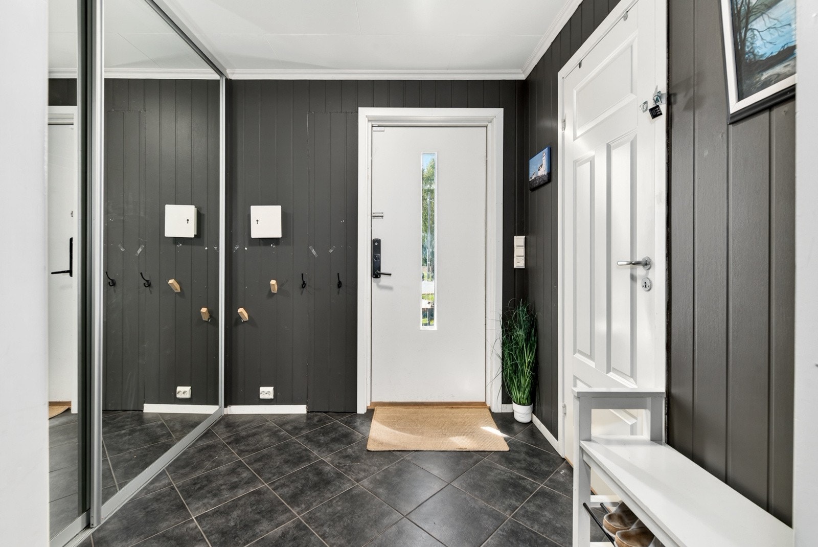 Entré har fliser på gulv med varmekabler og skyvedørsgarderobe med speildører for oppbevaring av ytterklær. Galleribilde