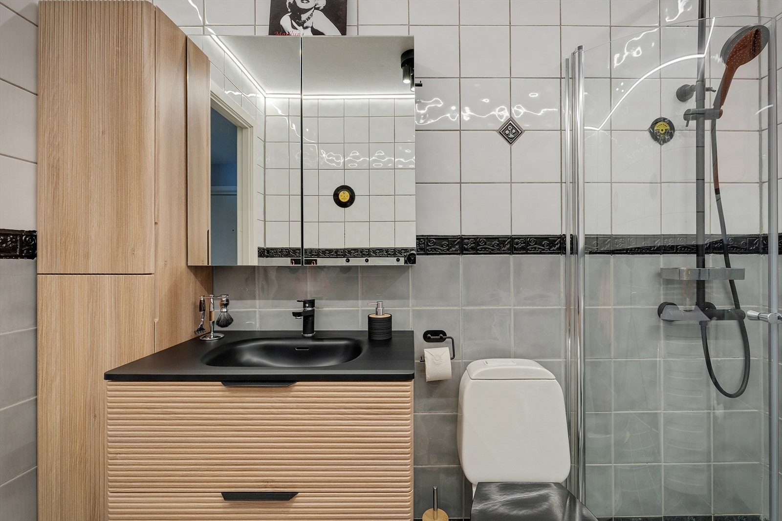 Baderomsinnredning med benkeskap, nedfelt servant og speil med belysning. Galleribilde