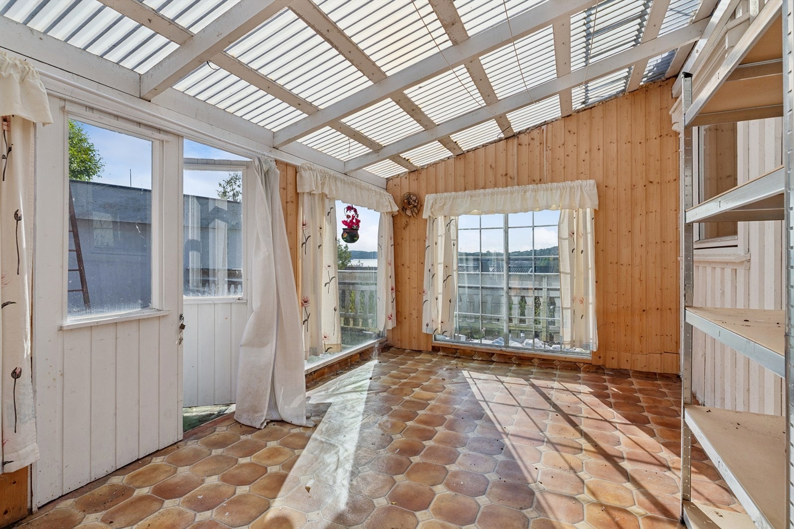 Vinterhage med trepanel på veggene og utgang til terrasse. Galleribilde