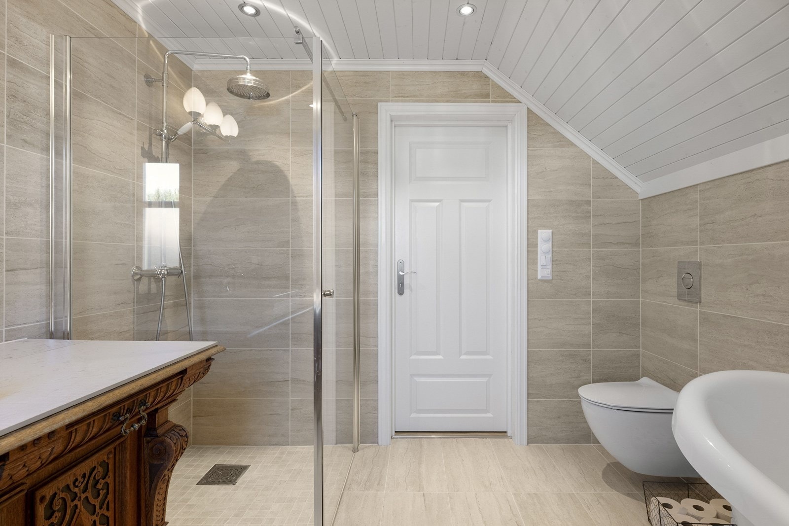 Stort dusjhjørne med regnfallsdusj. Det er downlights i himlingen. Galleribilde