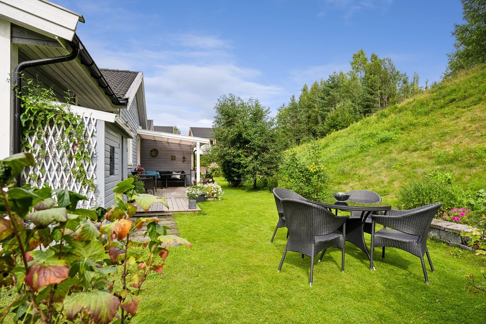 Stor, delvis overbygget terrasse på baksiden av huset. Galleribilde