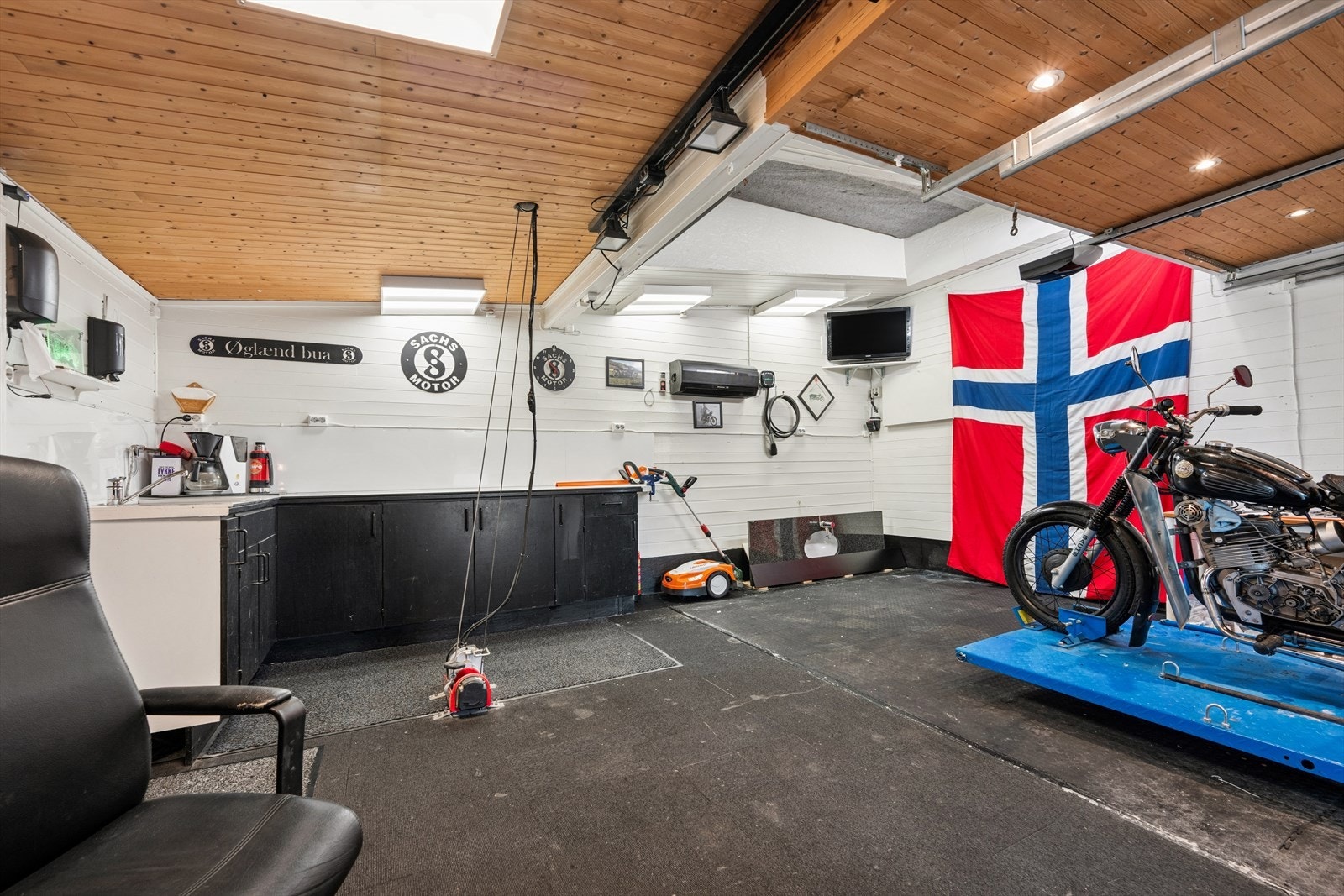 Romslig garasje med en praktisk løfteplattform for enkel tilgang til loftet. Galleribilde