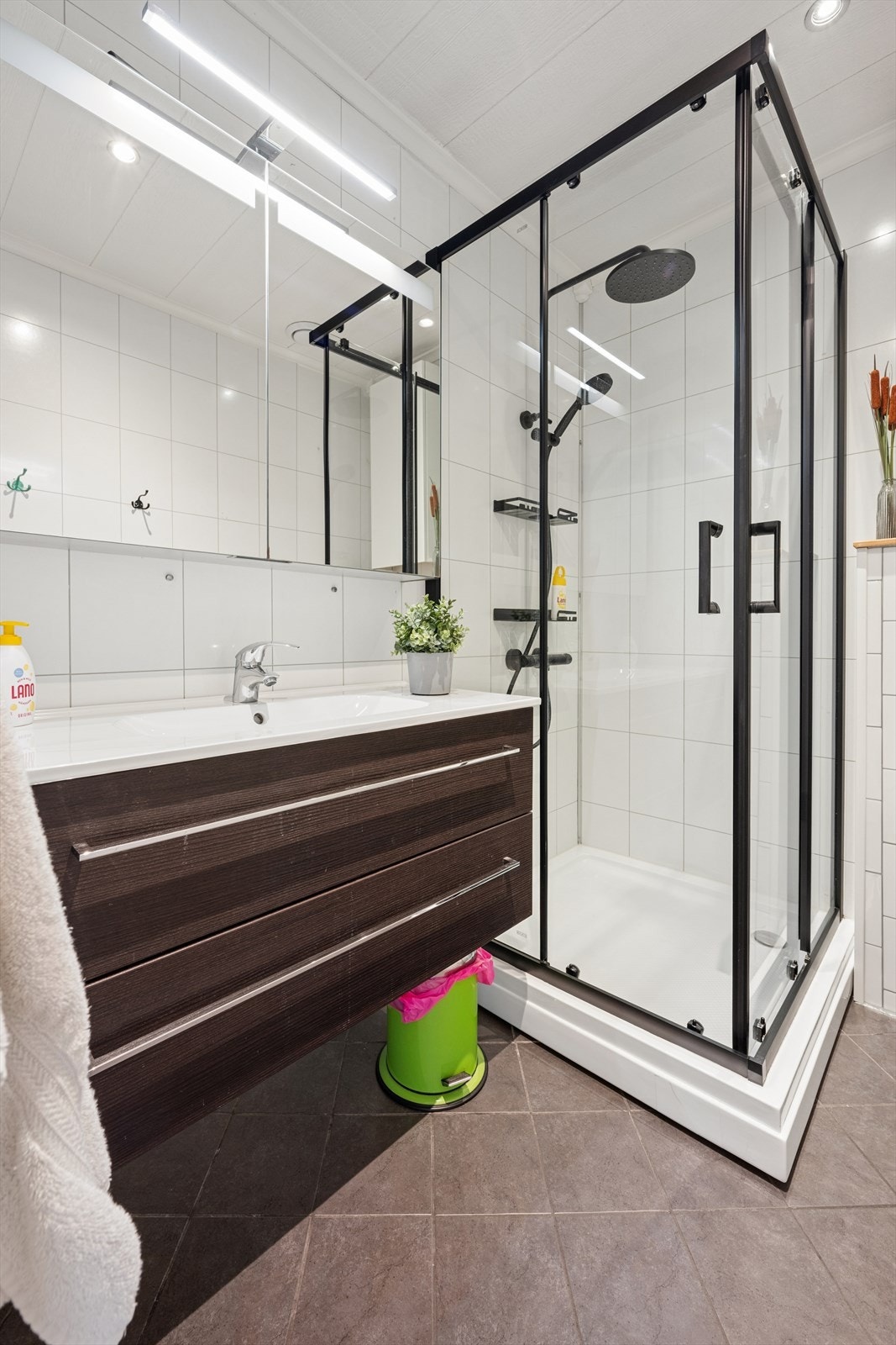 Badet er innredet med dusjkabinett, servant og vegghengt toalett. Galleribilde