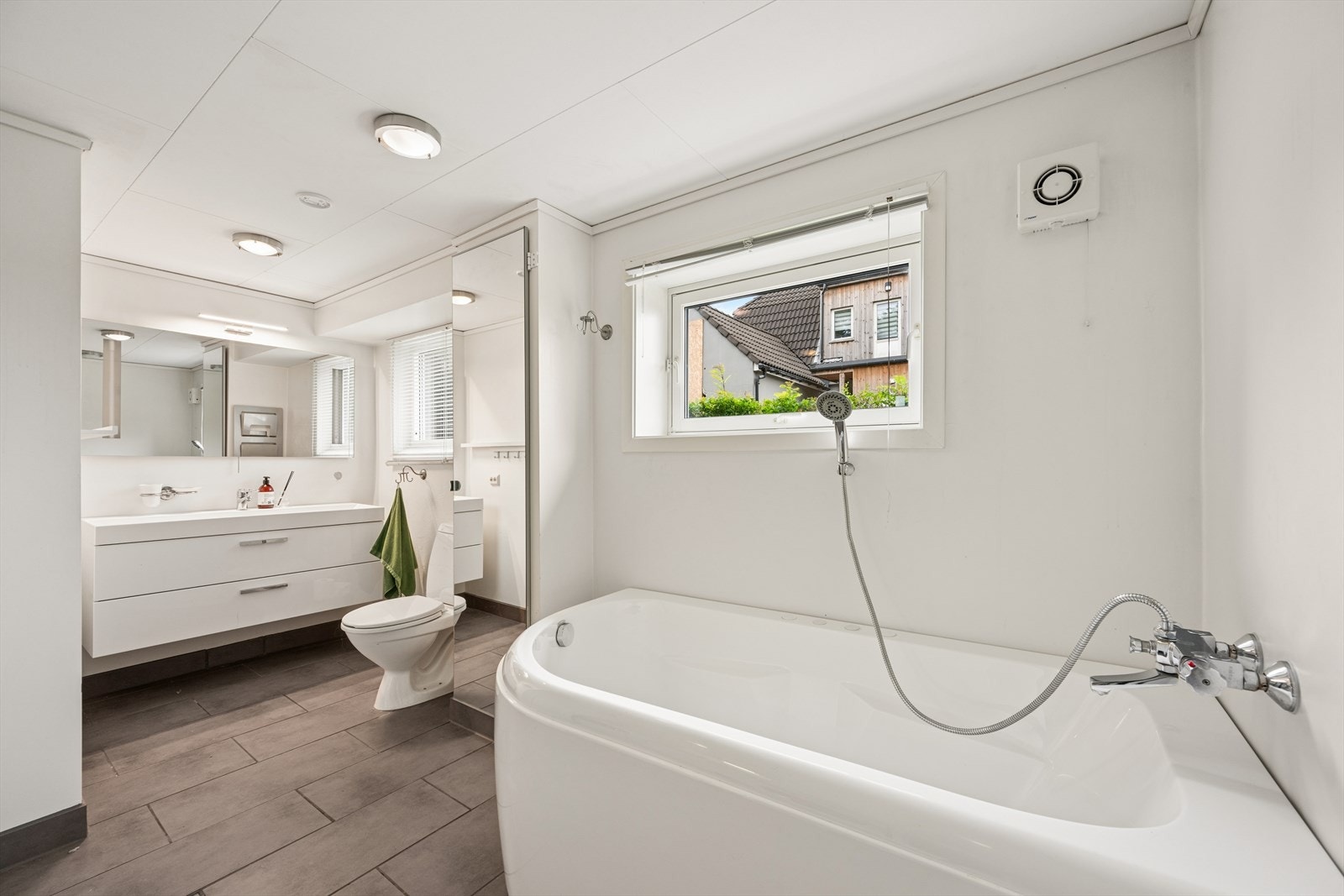 Kombinert bad og vaskerom i kjelleren, med badekar og opplegg for vaskemaskin. Galleribilde