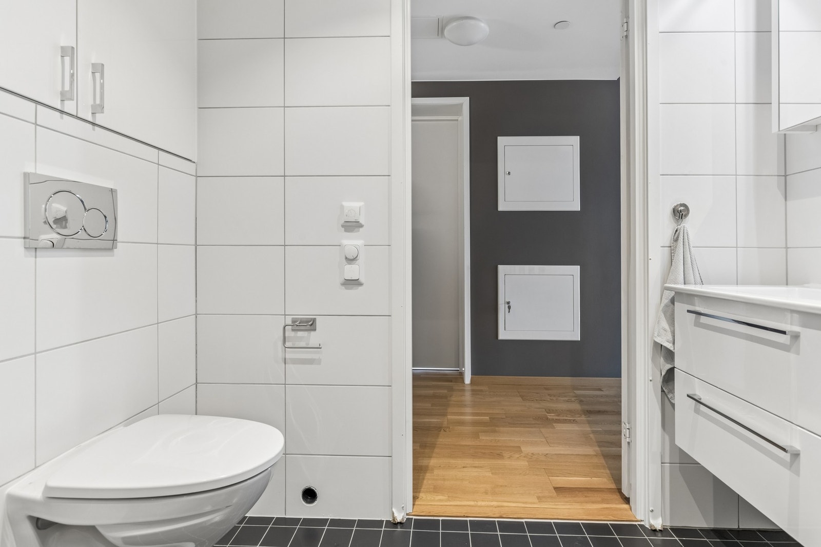Bad med dusjnisje, vegghengt toalett og moderne overflater. Galleribilde