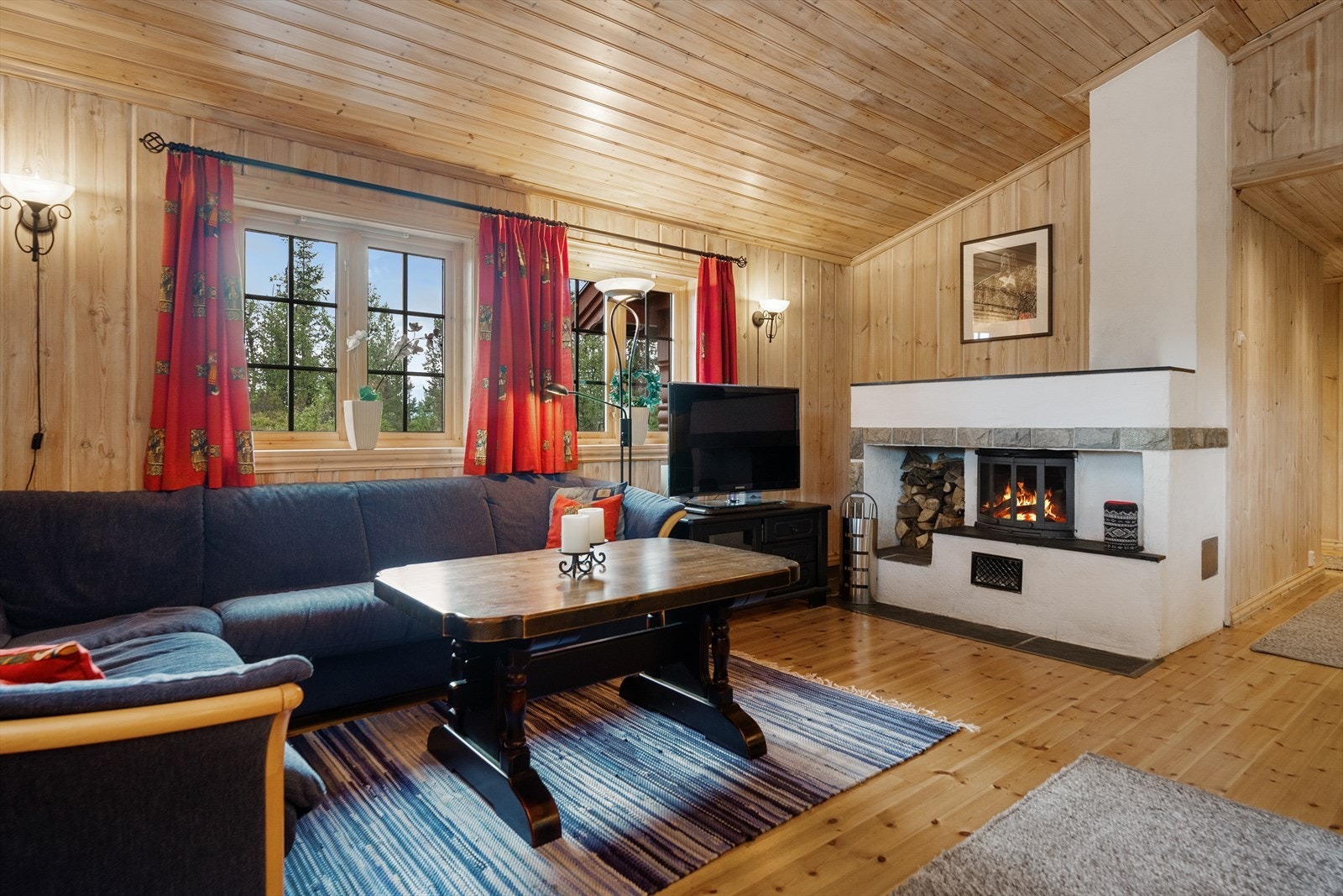 Sentralt i rommet er det etablert peis med innsats, som gir lun og god varme på kalde dager. Galleribilde