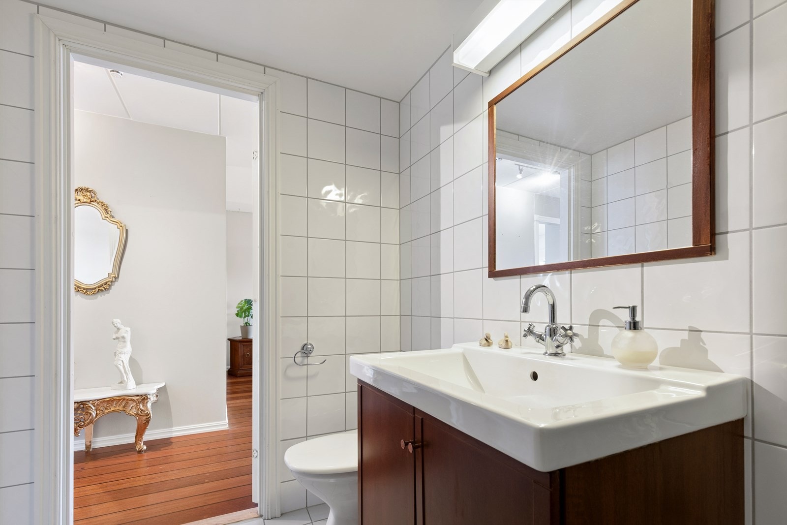 Badet er innredet med servantskap, toalett og dusjhjørne. Galleribilde