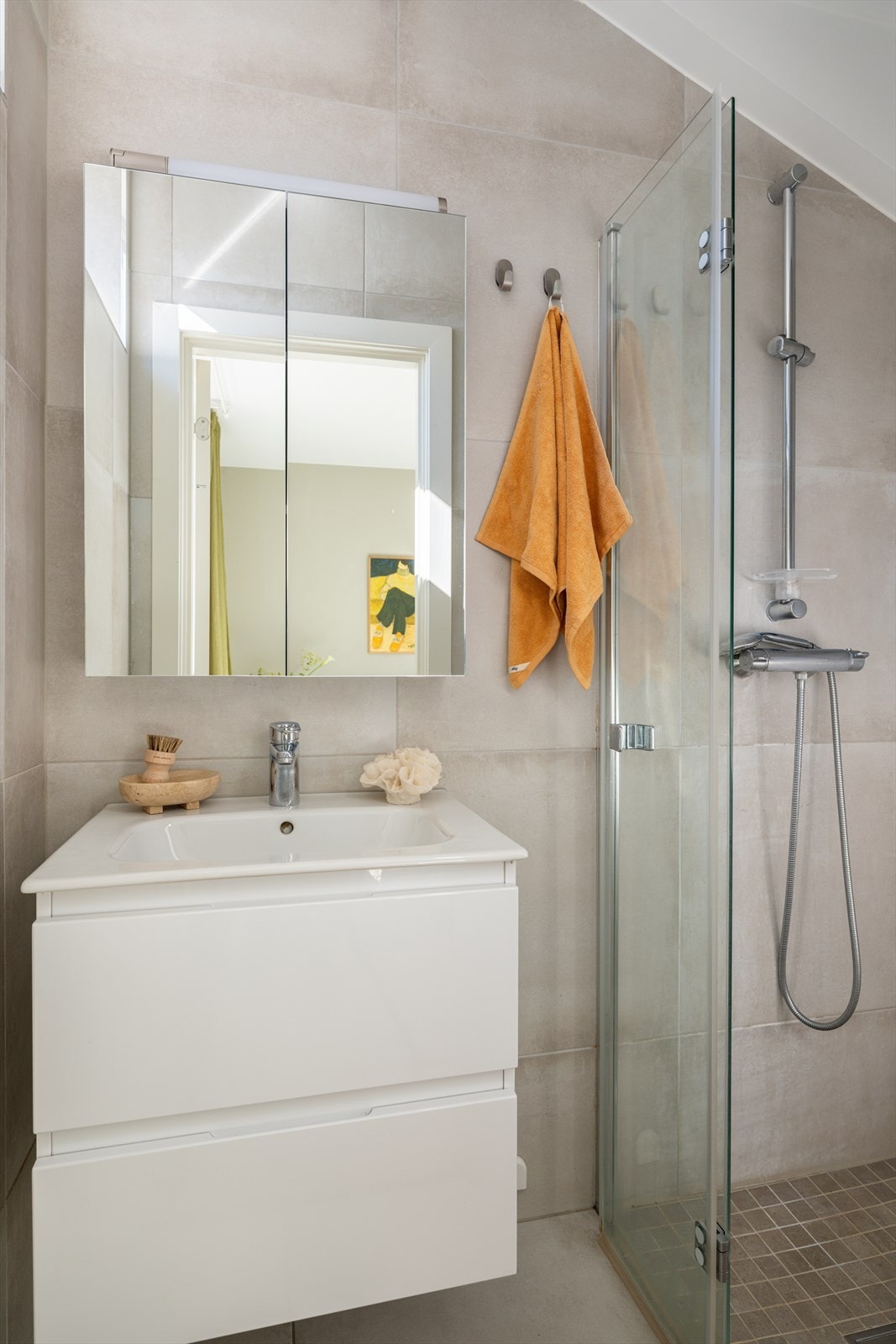 Badet oppleves romslig og lyst, med tidløse fliser på vegger og gulv. Galleribilde