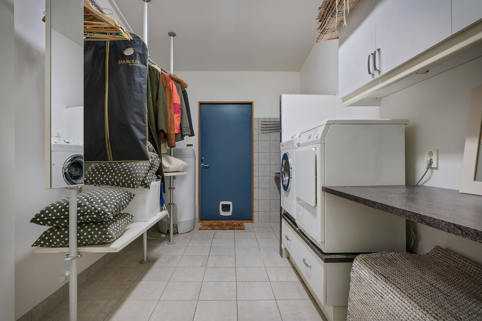 Separat vaskerom med flislagt gulv, opplegg for vaskemaskin og egen utgang til garasjen. Galleribilde