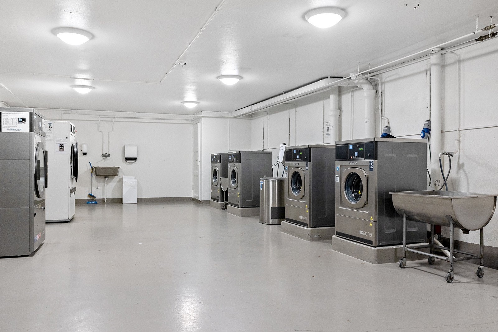 Praktisk fellesvaskeri med store industrimaskiner. Galleribilde