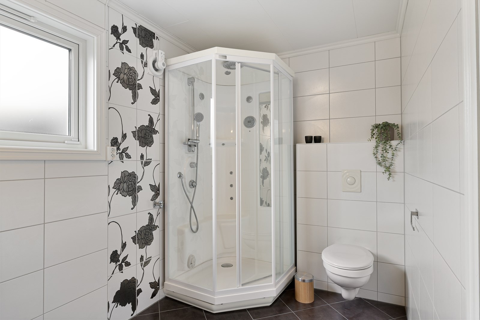 Badet er utstyrt med vegghengt toalett og dusjkabinett. Galleribilde