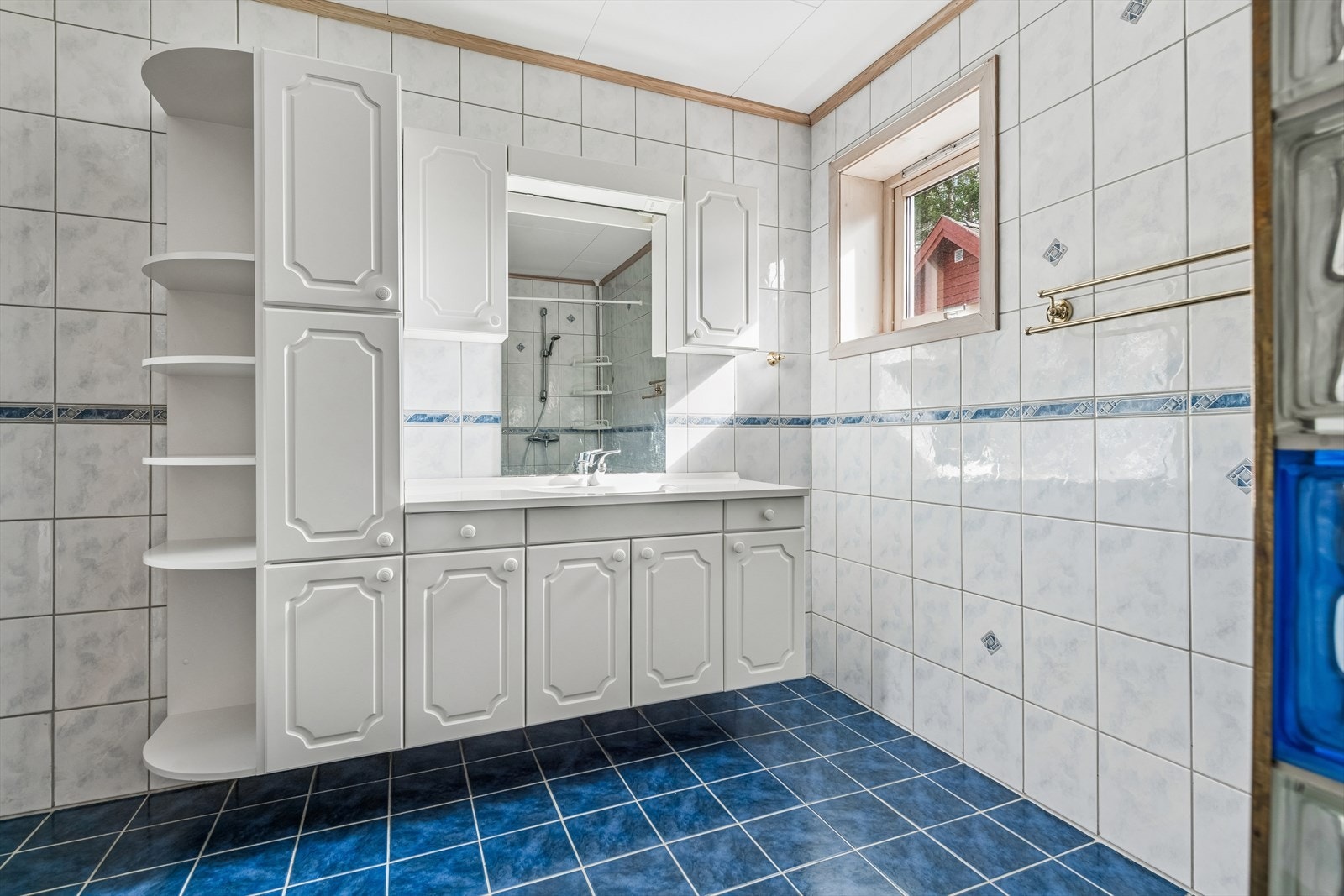 Badet inneholder dusjhjørne m/glassbyggerstein, gulvstående toalett og en innholdsrik baderomsinnredning. Galleribilde