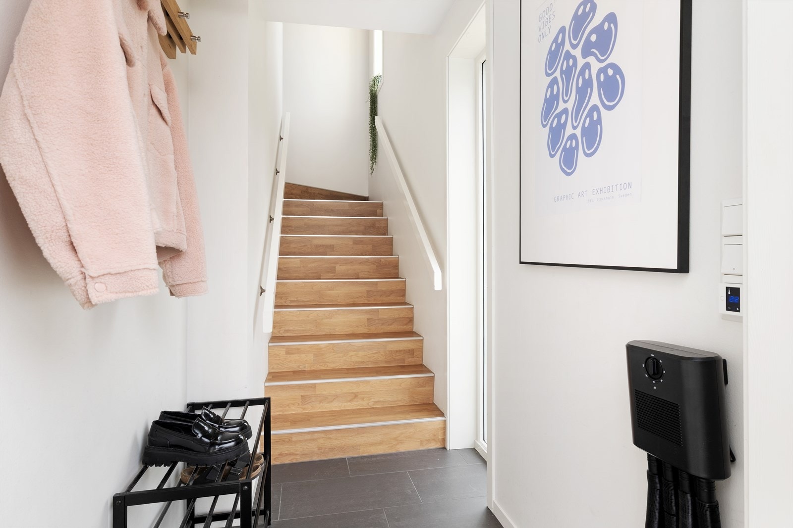 Lyst vindfang med vindauge i trappa og flislagt golv.
Plass til oppbevaring av ytterklede og sko. Galleribilde