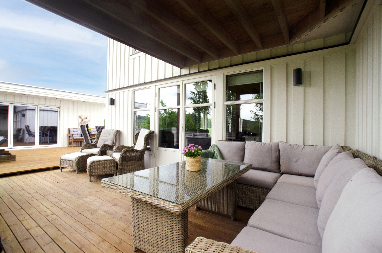 Utgang til stor og delvis takoverbygd terrasse fra stue i 1. etasje. Galleribilde