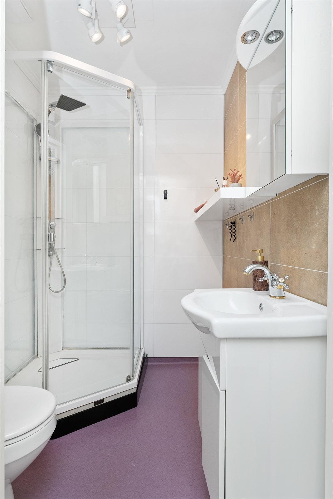 Badet er utstyrt med dusjkabinett og toalett. Galleribilde