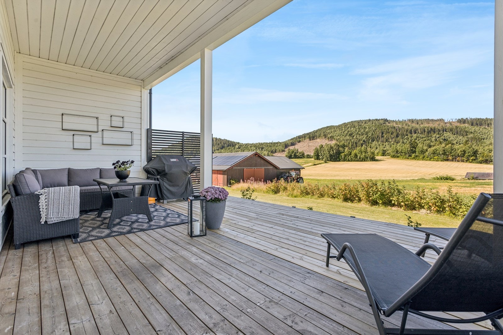 Verandaen har kveldssol og gressplen foran. Galleribilde