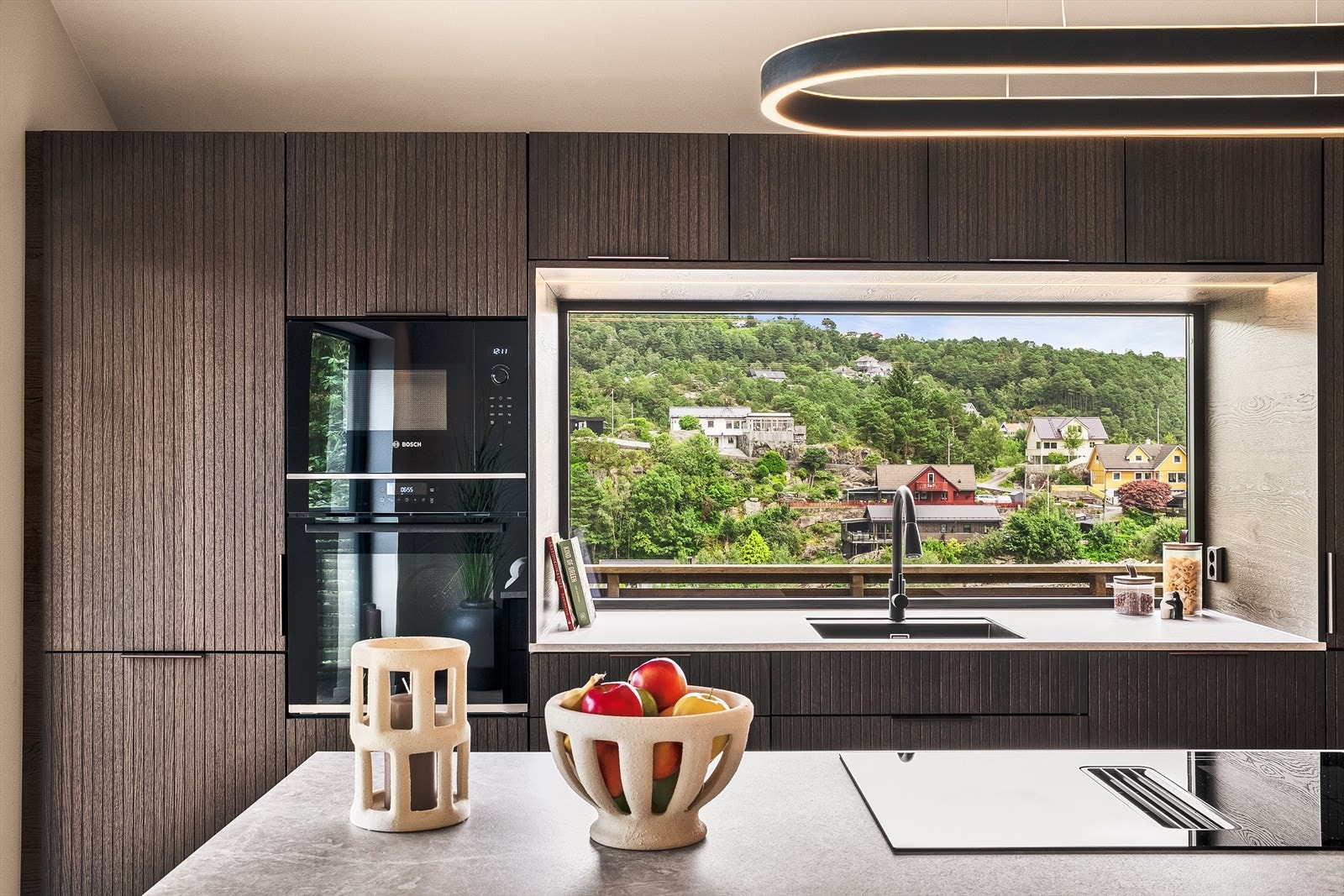 Den sentrale kjøkkenøya er utstyrt med platetopp og nedfelt ventilator, og kjøkkenet har integrerte hvitevarer som stekeovn, mikrobølgeovn, kjøleskap og oppvaskmaskin. Underlimt vask gir et rent og elegant preg. Galleribilde