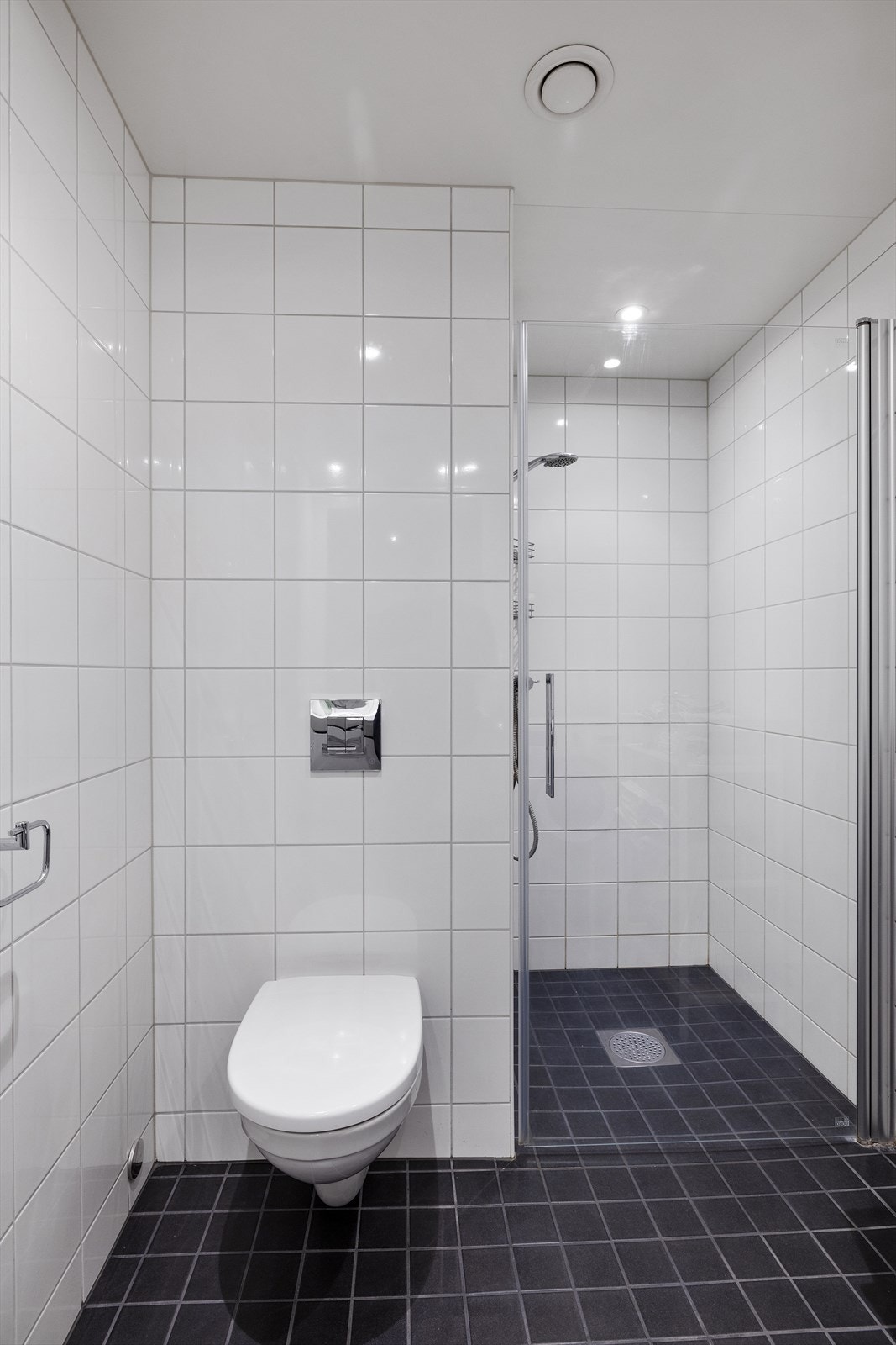 Badet fremstår lyst og innbydende, med downlights i himlingen som gir en jevn og behagelig belysning. Det er opplegg for vaskemaskin. Galleribilde