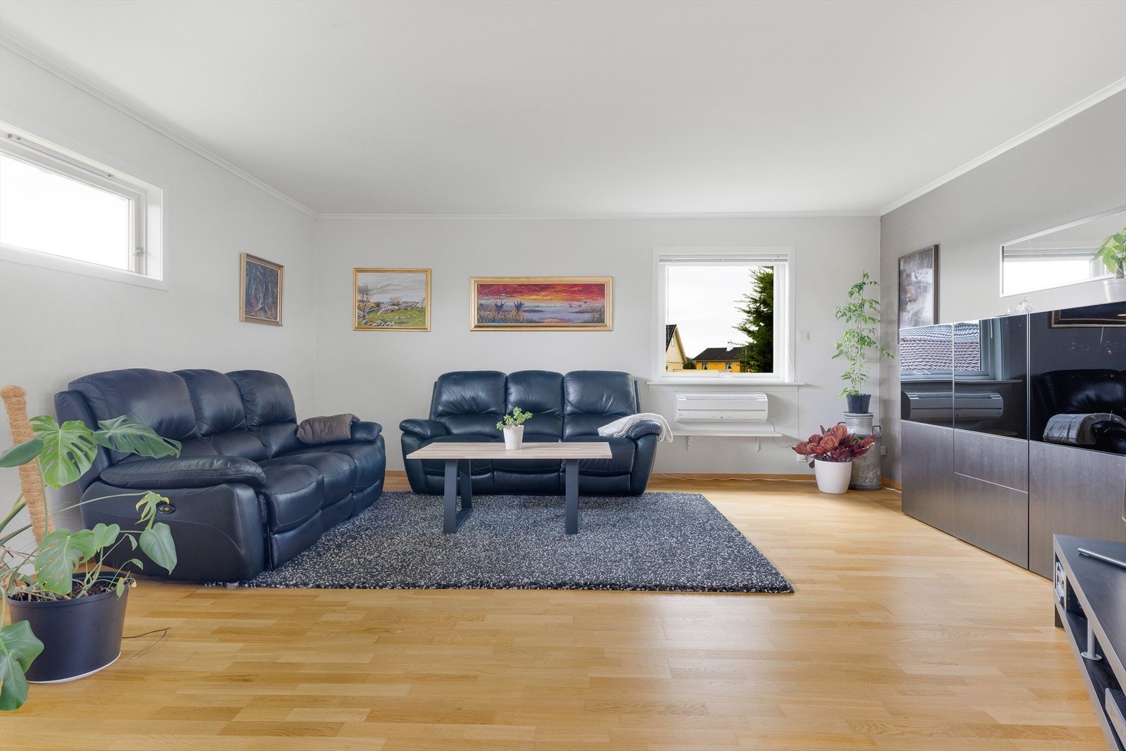 Mye vindusflater gir rikelig med naturlig lys inn i stuen. Galleribilde