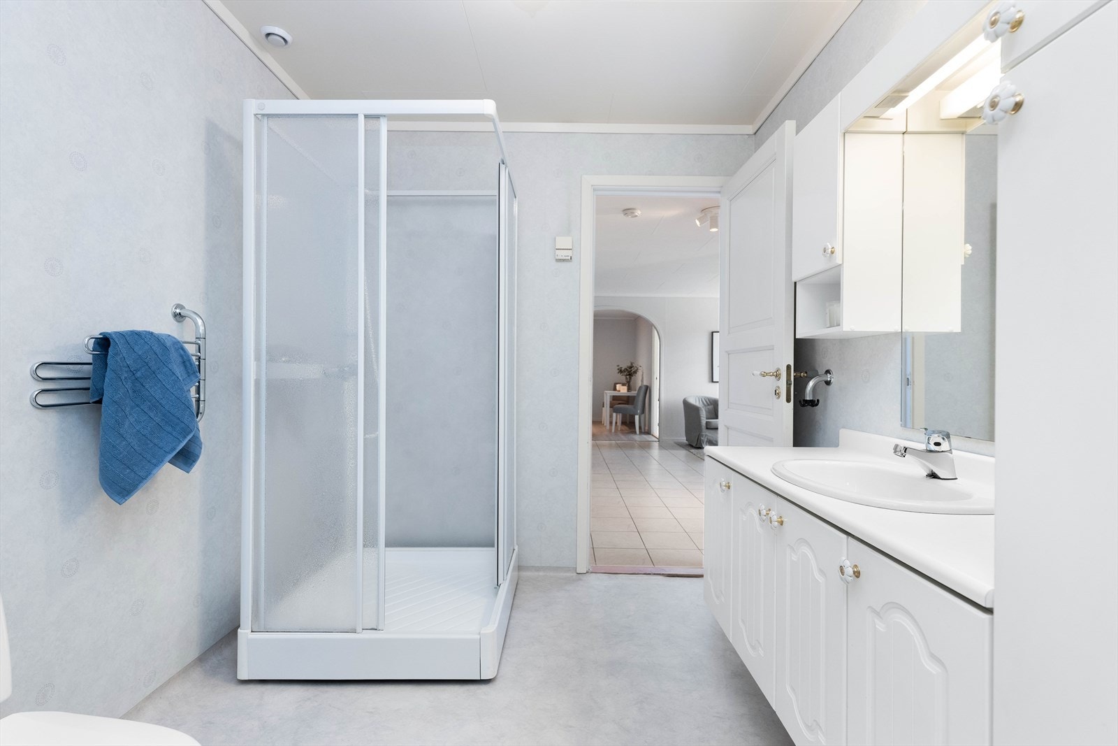 Badet er innredet med toalett, dusjkabinett og benkeskap med servant. Galleribilde
