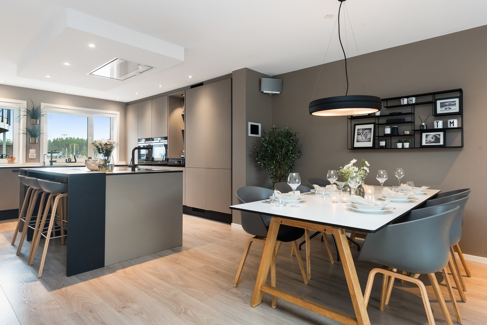 Spiseplass i åpen løsning med kjøkkenet, med plass til mange gjester. Galleribilde