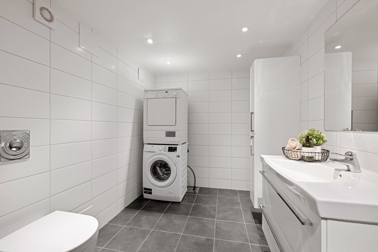 Badet har dusjnisje, vegghengt toalett og opplegg for vaskemaskin. Galleribilde