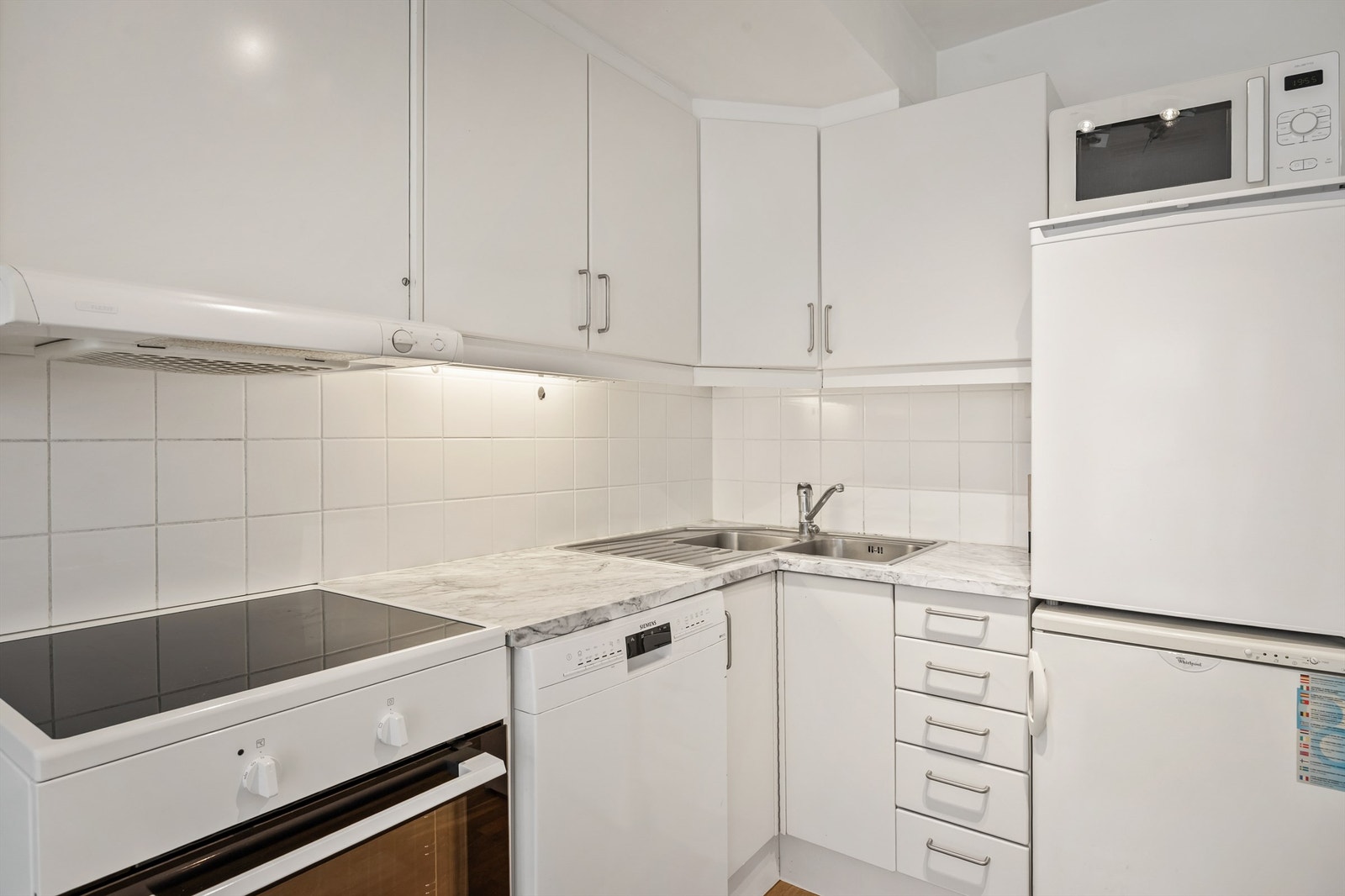 Kjøkken med innredning med glatte fronter. Benkeplate med laminert overflate og nedfelt kjøkkenvask. Galleribilde