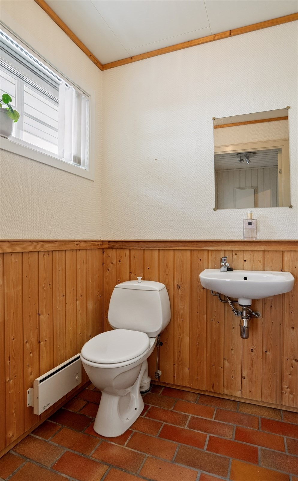 Toalettrommet i første etasje er innredet med servant og toalett. Gulvet er flislagt, mens veggene har brystpanel og tapet. Oppvarming skjer via veggmontert panelovn. Galleribilde