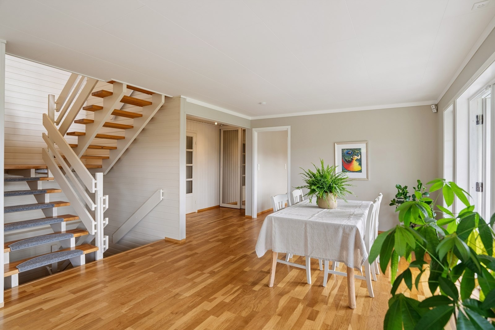 Du ønskes velkommen inn i en entré med god plass til oppheng av yttertøy. Herfra er det adkomst til et praktisk toalettrom. Videre åpner boligen seg mot stue- og spiseområdet, mens trappen gir enkel adkomst til boligens øvrige etasjer. Galleribilde