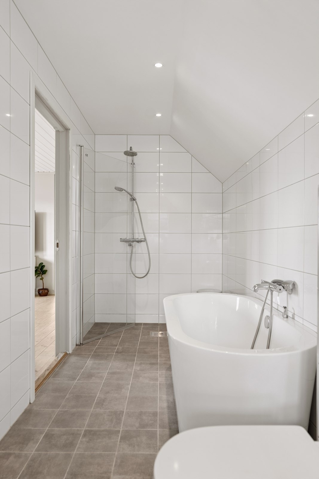Badet er innredet med vegghengt toalett, badekar og dusjnisje med glassdør. Gulvet har elektriske varmekabler og vegger og gulv er flisbelagt. Ventilasjon skjer via elektrisk styrt avtrekksvifte, kombinert med tilluft gjennom luftespalte over dørbladet. Galleribilde