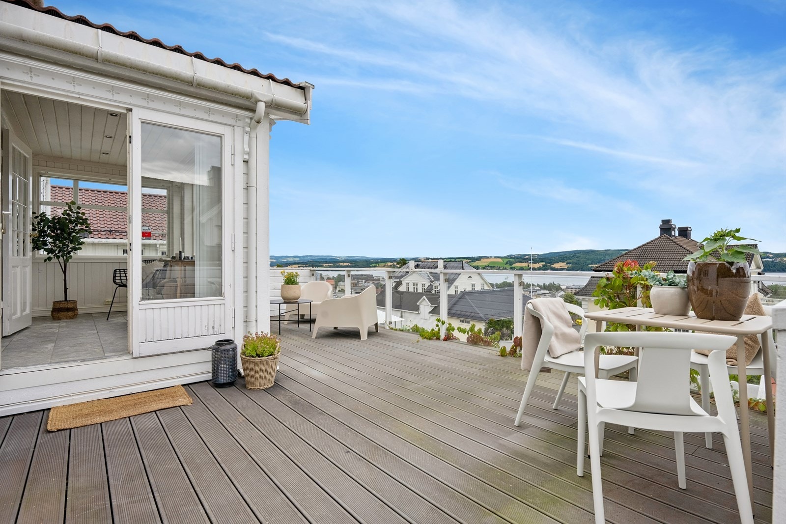 Terrassen har rekkverk i tre og glass, og er en naturlig forlengelse av stuen på sommerstid. Galleribilde