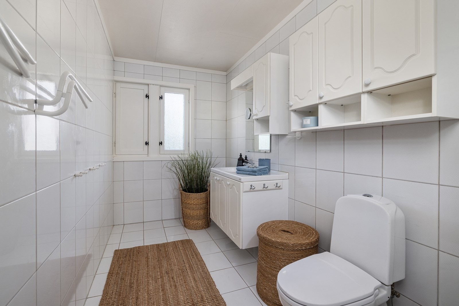 Badet er utstyrt med dusjhjørne, toalett og baderomsinnredning med overskap. Galleribilde