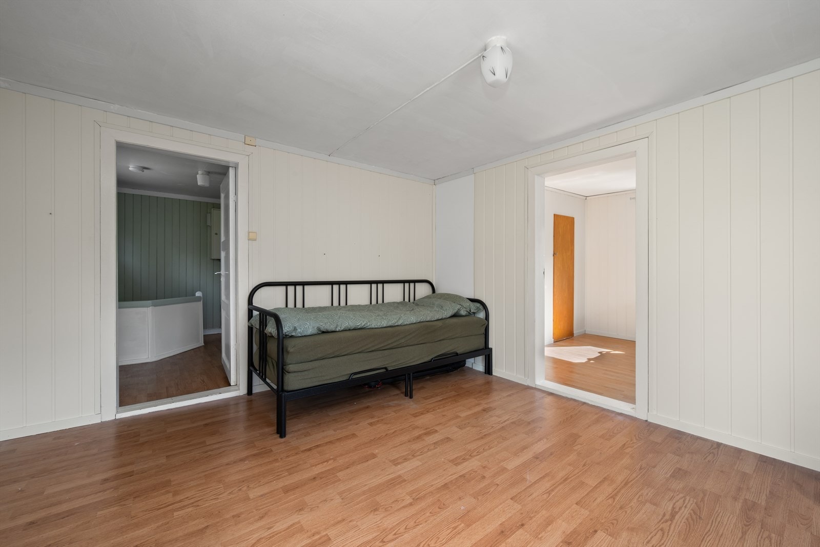 Soverom 2 med malt panel på vegg og laminat på gulv. Galleribilde
