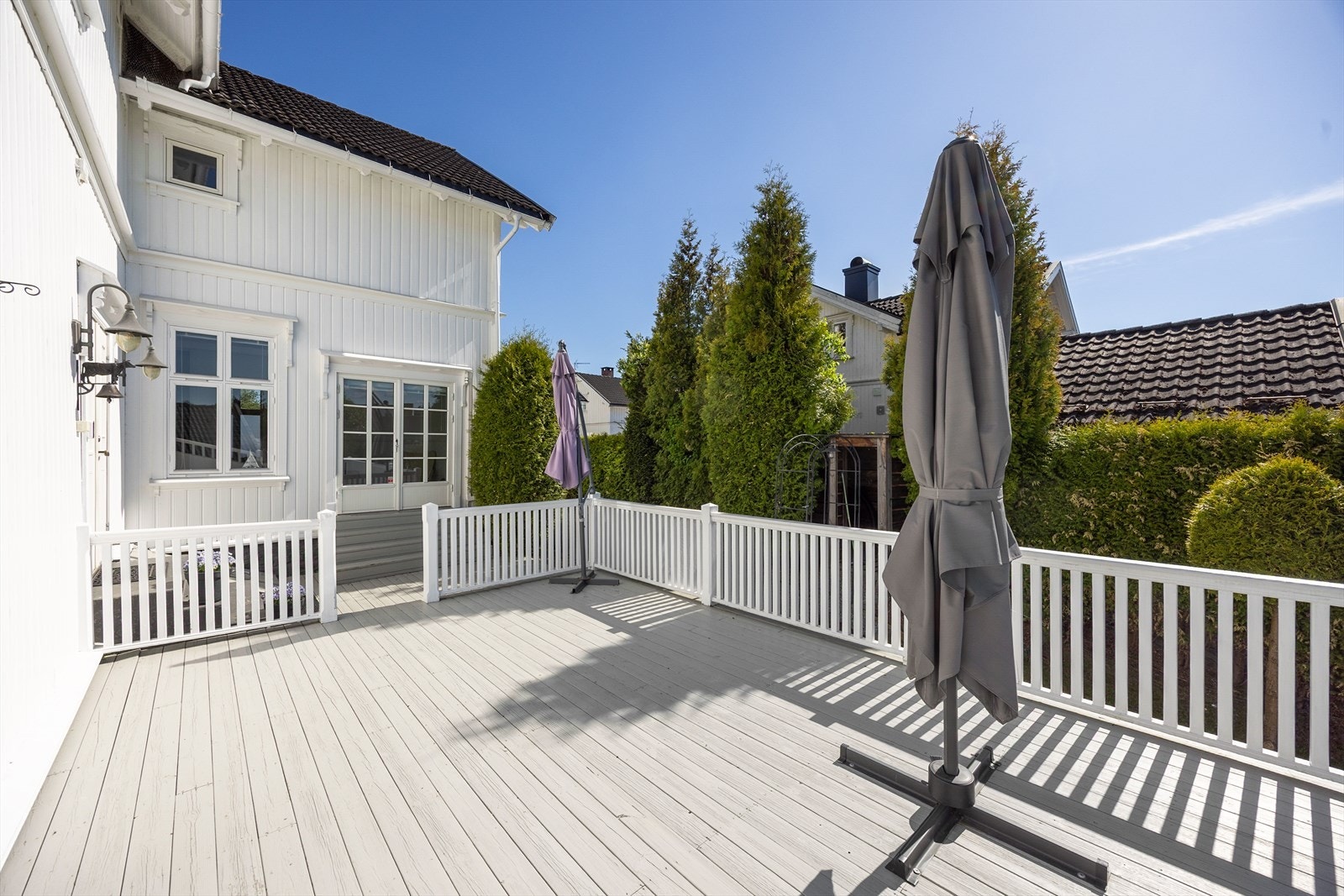 Ved inngangen har boligen en veranda og en delvis overbygd terrasse, og sammen skaper de et stort uterom med ulike soner for familien. Galleribilde