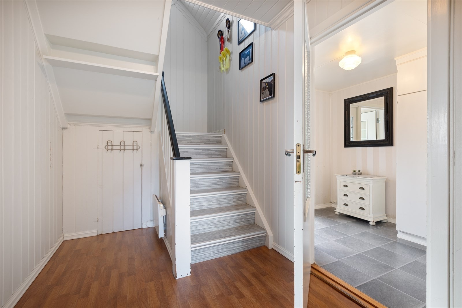 Fra entréen er det en separat gang med adkomst til 2.etasje og kjøkkenet. I gangen er det også ekstra oppbevaringsplass under trappen. Galleribilde