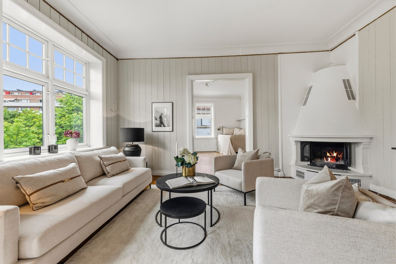 En elegant peis blir et naturlig midtpunkt i rommet, mens doble fløydører skaper en flott forbindelse til de tilstøtende rommene. Galleribilde