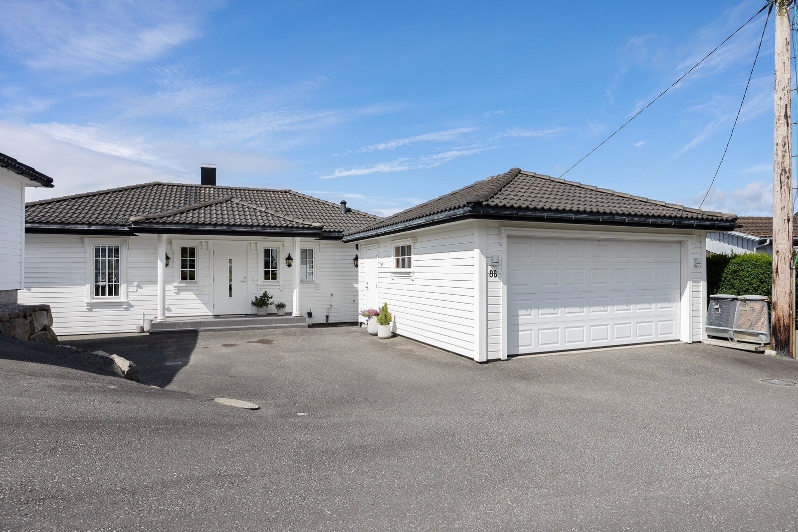 Frittstående garasje med motorisert leddport, oppført i samme stil som boligen. Galleribilde